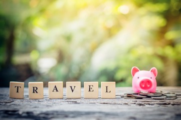 Business concept, hand putting coins in pink piggy bank for travel