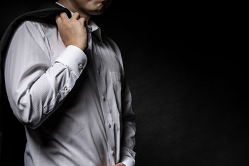 スーツのジャケットを肩に掛けた男性