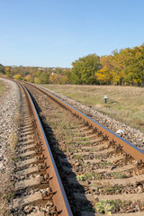 Autumn landscape with railway and oak grove