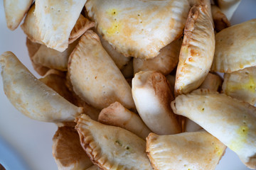 Pile of Nigerian Meat Pies in Plastic Bowl