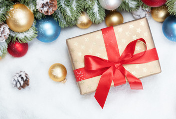 christmas gift with red ribbon and bow with decoration on snow