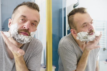 Guy shaving his beard in bathroom