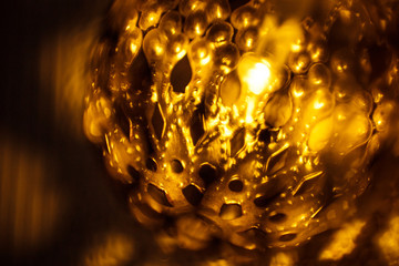 Festive garland carved metal bowl is lit from within with a Golden light. Bronze balls with...
