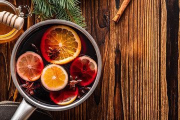 Mulled wine hot drink with citrus, apple and spices in aluminum casserole and Fir branch on...