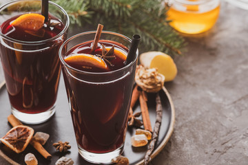Hot mulled wine with spices, apple and orange on chrictmas background. Copy space.