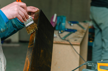 Carpenter covers wood furniture parts with wood wax
