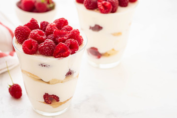 Raspberry dessert, cheesecake, raspberry tiramisu, trifle, mousse in a glass on a white background.