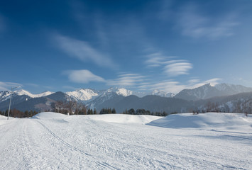 Fototapeta premium Empty road with huge snow banks on sides on cloudy winter day