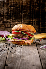 home made tasty burger with meat cutlet and cheese on wooden vintage table. vertical image. copy...