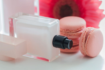 Beautiful pink perfume bottles with flower and macaroons.  Luxury perfumery background