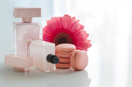 Beautiful pink perfume bottles with flower and macaroons.  Luxury perfumery background