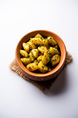 Jeera Aloo is a Indian main course dish which goes well with hot puris, chapatti, roti or dal. served in a bowl over moody background. selective focus