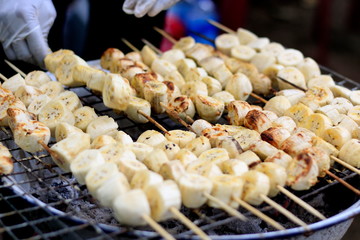 Grilled bananas are placed on the iron curry on charcoal stove.