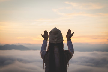 Young christian woman  hands open palm up worship and praying to god  at sunrise, Christian Religion concept background.