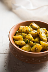 Jeera Aloo is a Indian main course dish which goes well with hot puris, chapatti, roti or dal. served in a bowl over moody background. selective focus