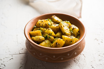 Jeera Aloo is a Indian main course dish which goes well with hot puris, chapatti, roti or dal. served in a bowl over moody background. selective focus