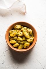 Jeera Aloo is a Indian main course dish which goes well with hot puris, chapatti, roti or dal. served in a bowl over moody background. selective focus