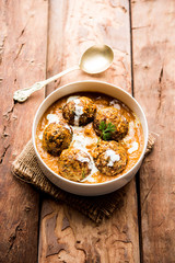 Malai Kofta is a Mughlai Speciality dish served in a bowl or pan over moody background. selective focus
