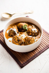 Malai Kofta is a Mughlai Speciality dish served in a bowl or pan over moody background. selective focus