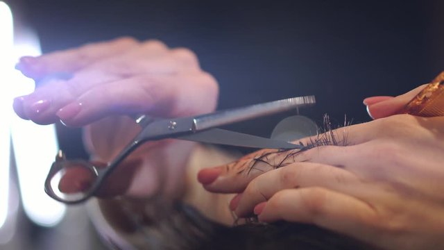 Close up of men's hair cutting scissors in a beauty salon. Frame. Close up of a haircut at a hair saloon. Professional barber styling hair of his client