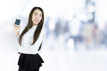 Asian business woman smiling, Holding blank screen smart phone on blurred background.