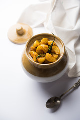 Homemade Gooseberry or amla Pickle/ or Aavle ka Achar in a bowl or barni over moody background.  selective focus