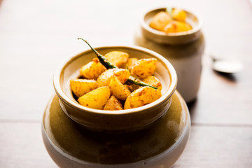 Homemade Gooseberry or amla Pickle/ or Aavle ka Achar in a bowl or barni over moody background.  selective focus