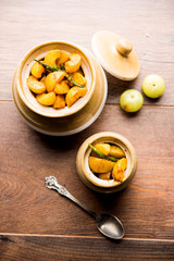 Homemade Gooseberry or amla Pickle/ or Aavle ka Achar in a bowl or barni over moody background.  selective focus