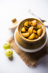 Homemade Gooseberry or amla Pickle/ or Aavle ka Achar in a bowl or barni over moody background.  selective focus
