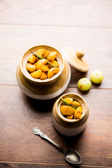Homemade Gooseberry or amla Pickle/ or Aavle ka Achar in a bowl or barni over moody background.  selective focus