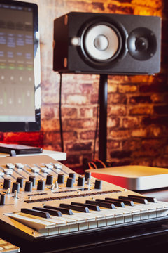 recording studio equipment. computer, midi keyboard synthesizer, loudspeakers, mixing console