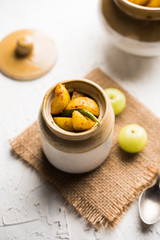 Homemade Gooseberry or amla Pickle/ or Aavle ka Achar in a bowl or barni over moody background.  selective focus