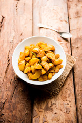 Homemade Gooseberry or amla Pickle/ or Aavle ka Achar in a bowl or barni over moody background.  selective focus