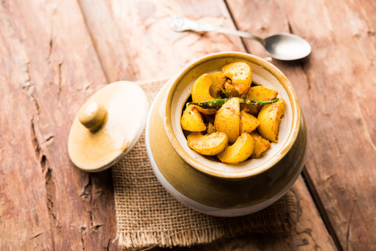 Homemade Gooseberry or amla Pickle/ or Aavle ka Achar in a bowl or barni over moody background.  selective focus