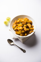 Homemade Gooseberry or amla Pickle/ or Aavle ka Achar in a bowl or barni over moody background.  selective focus