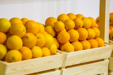 Oranges, juicy, many, lie in a wooden box.