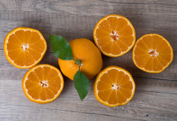 Fresh ripe tangerines with leaves on a wooden background.