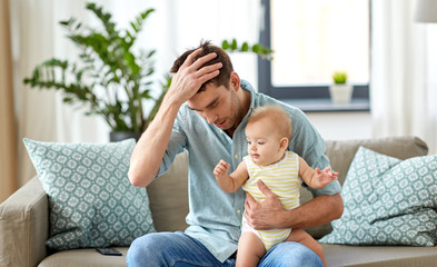 family, fatherhood and people concept - despaired father with little baby daughter at home