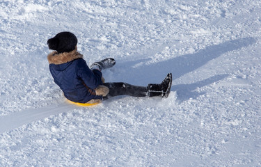 Girl sledding from the mountain in winter