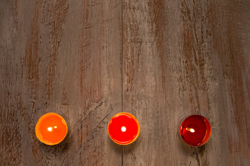 Colorful candles on the wooden boards.
