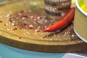 Red pepper and spilled seasonings on the background of wooden boards.