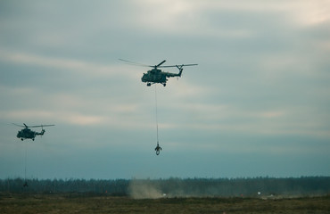 military army helicopter transporting an artillery piece. © yarohork