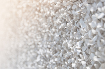 Closeup white walls of the fake foliage with yellow sunlight and defocus bokeh background.