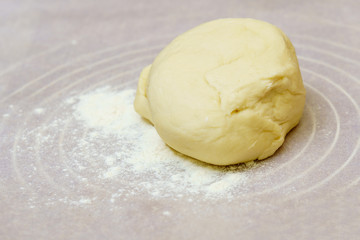 Homemade dough is cut in half on a floured surface.