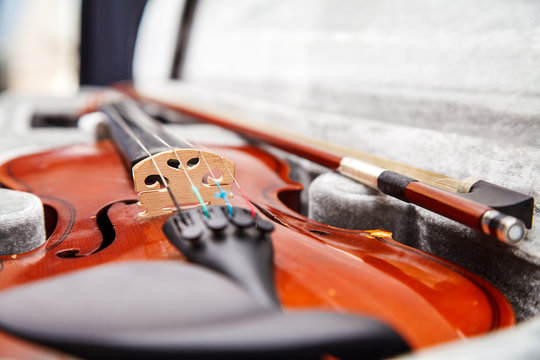 brown vintage violin lying in a case