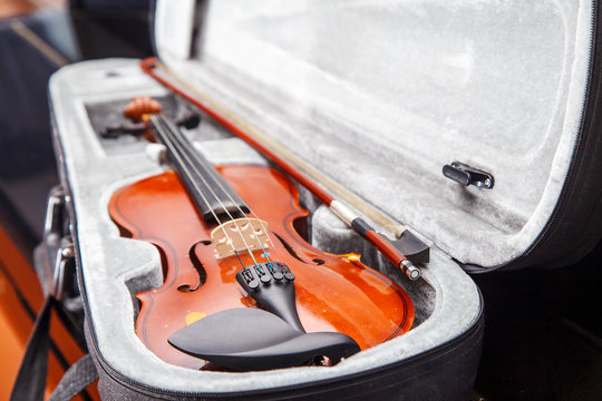 brown vintage violin lying in a case