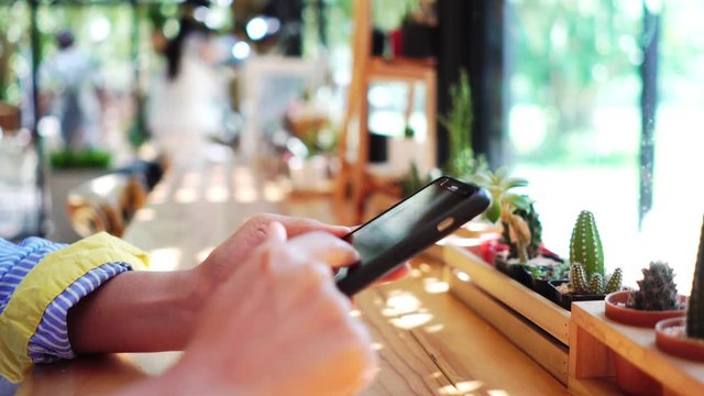 Woman hand using smartphone in  cafe background. Business, financial, trade stock maket and social network concept.