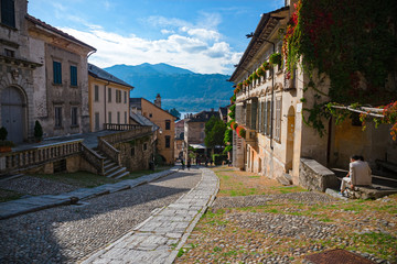 Some tourists go down the main street of the picturesque historical village of Orta, on the lake of Piedmont in Italy.