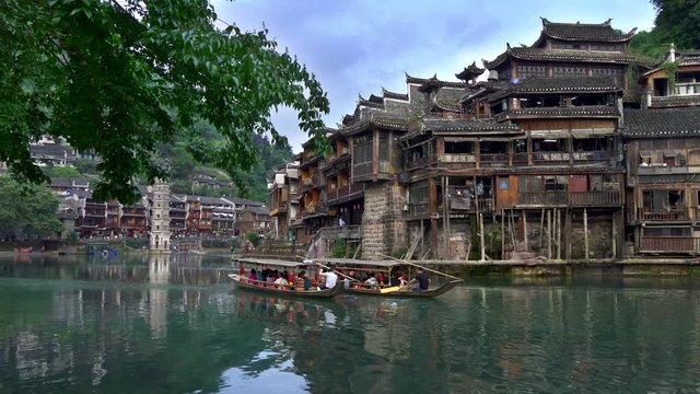 Fenghuang County, China. Tourists are given a ride on boats on the river in the Ancient Town. UHD