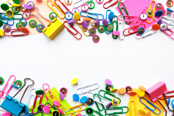 Fototapeta premium Colorful stationary, back to school, office, business and education concept. School and office supplies paper clips, pins, notes, stickers on white background, flatlay. Mock up. Top view, close up